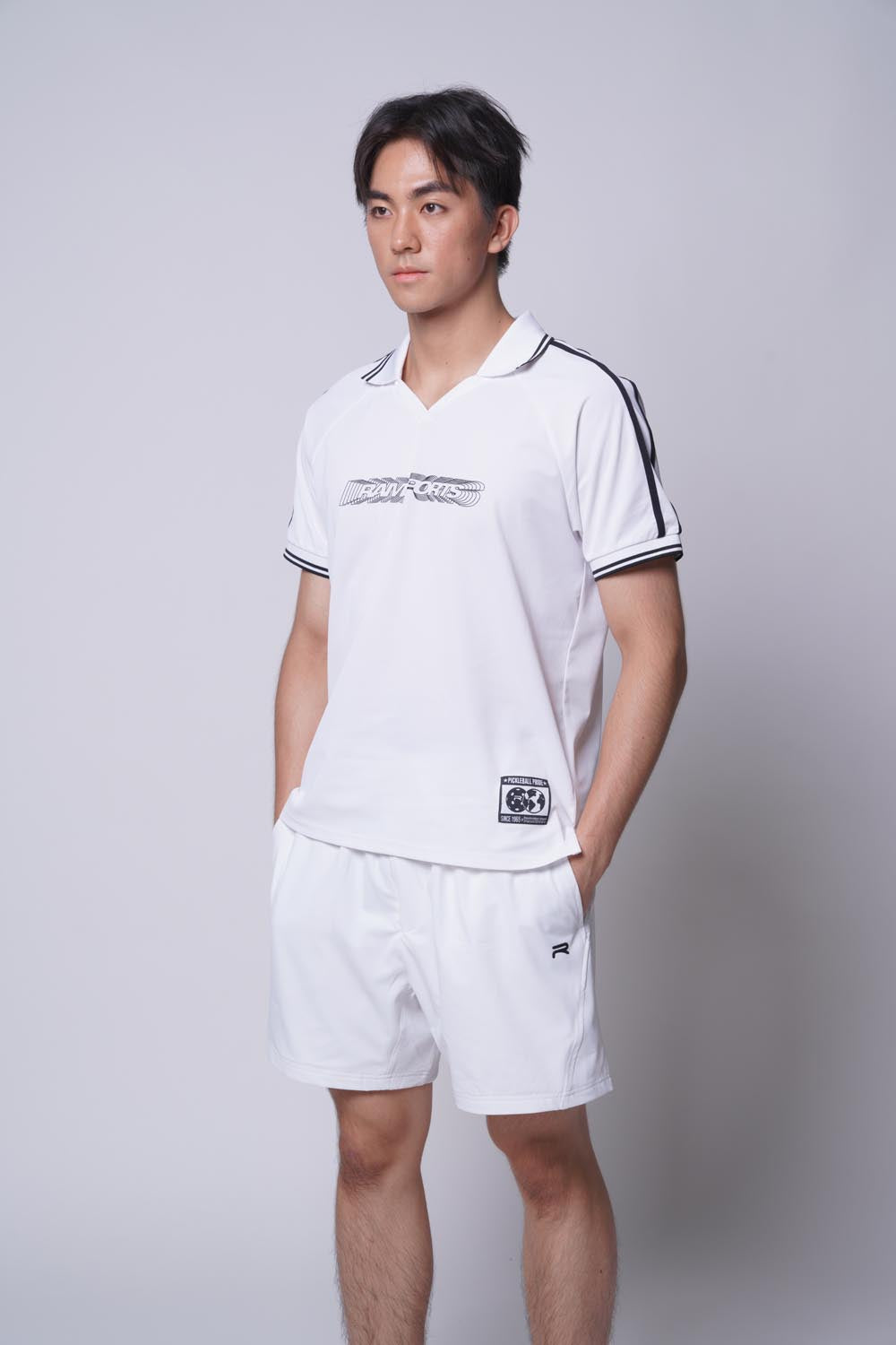 Male model standing sideways with both hands on pocket, wearing of Ramsports MatchDay Core Short in white