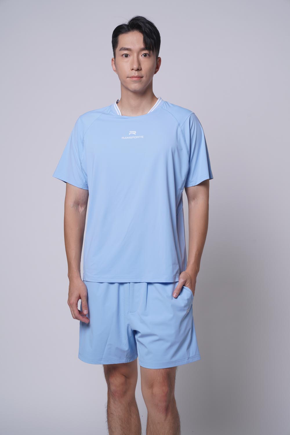 Male model standing straight with one hand on pocket wearing Ramsports Edge Line Raglan Tee in blue