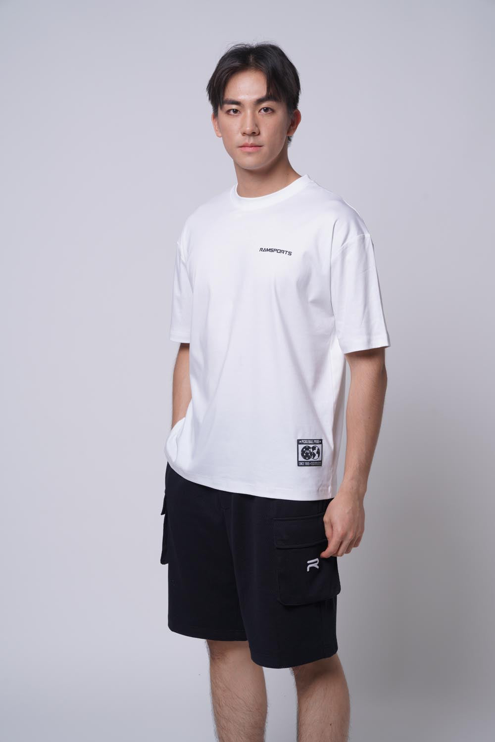 Asian male model with white top wearing Ramsports Court Cargo Utility Short in black